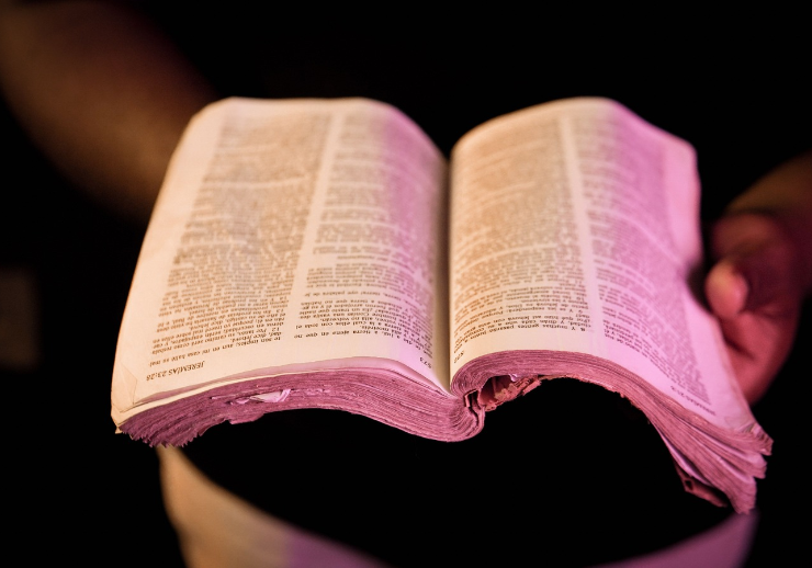 Une Bible ouverte tenue entre les mains